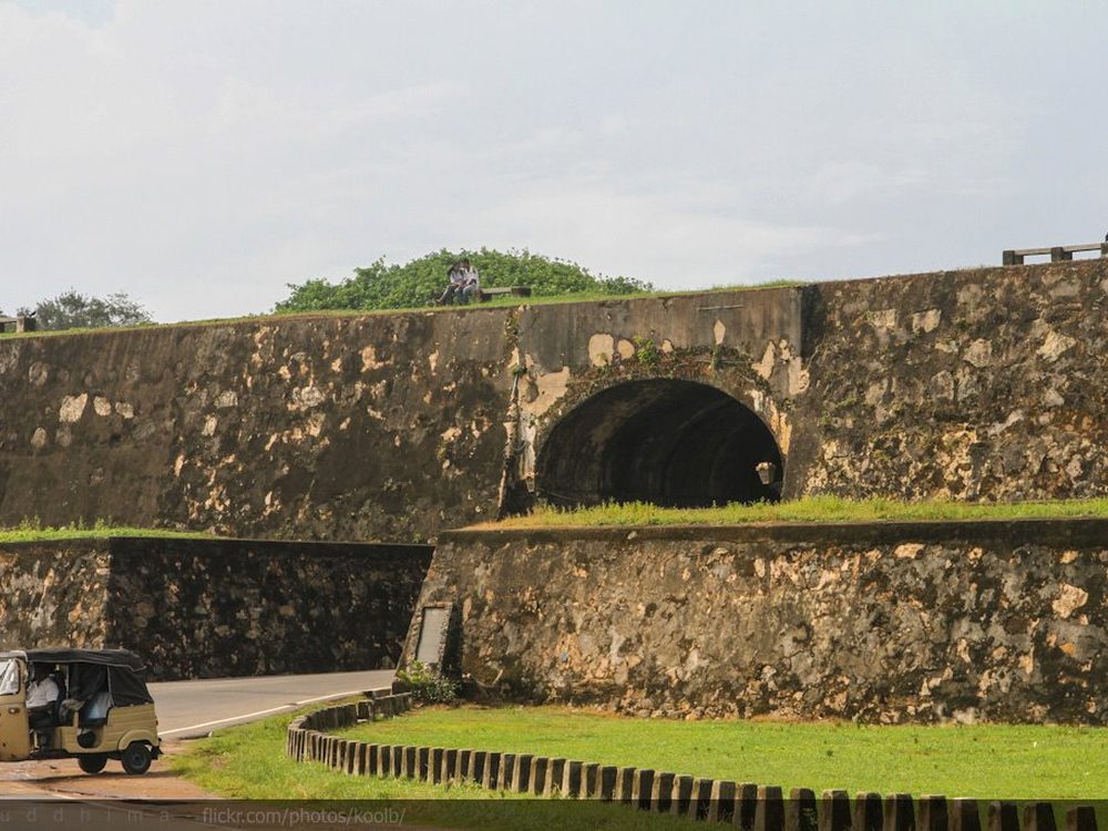 The rampart walls of Galle Fort with a tuk-tuk on the road below